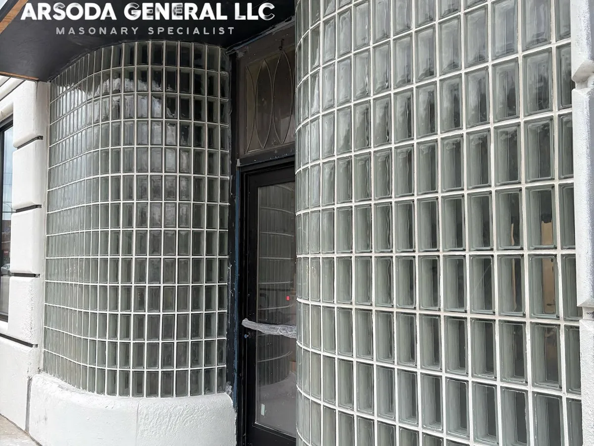Two curved glass block columns flanking the entrance of a white commercial storefront