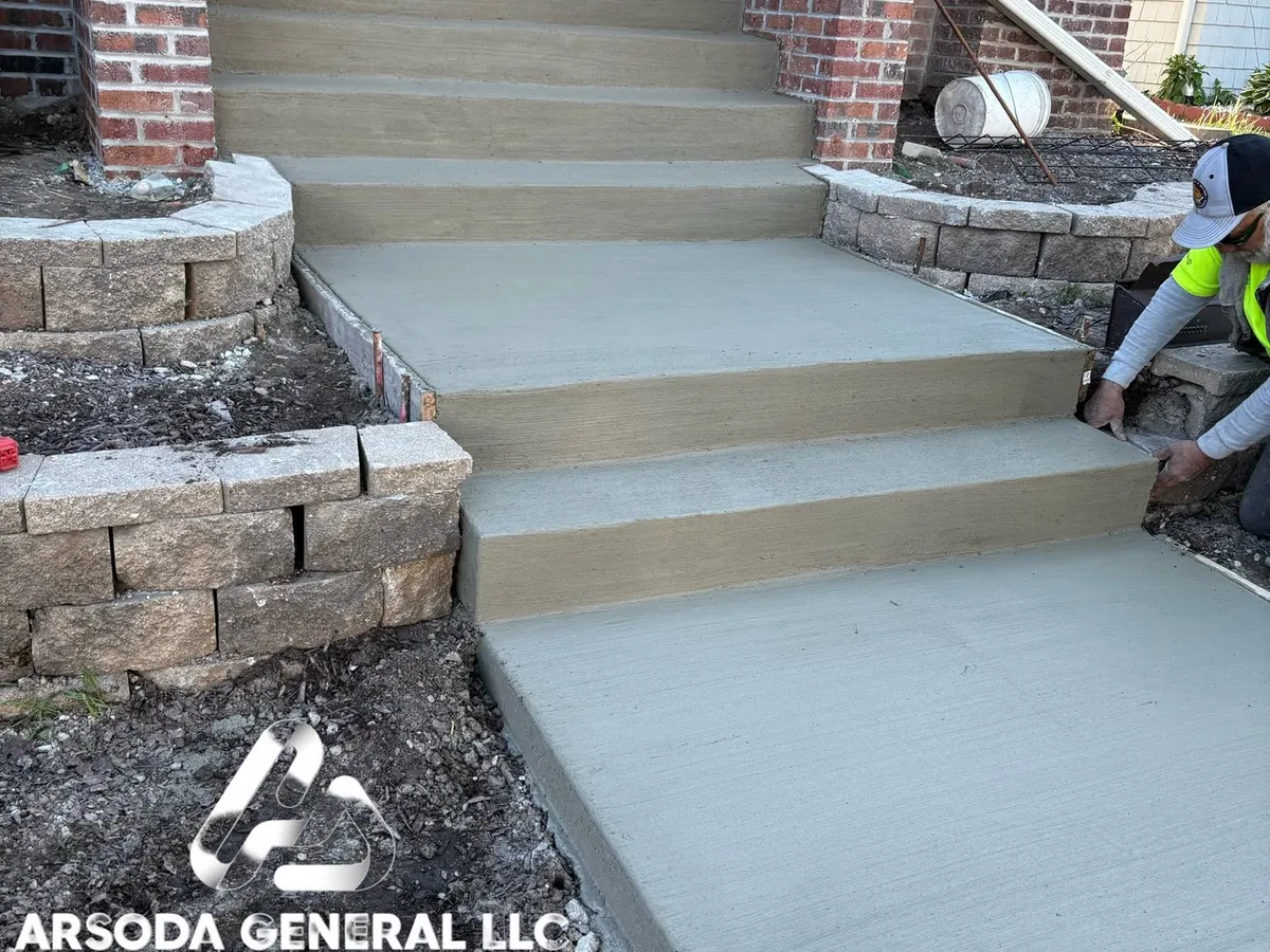 Concrete entry steps set between stone retaining walls at a brick home