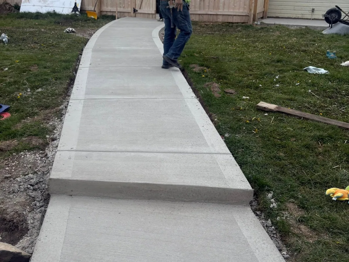 Curved concrete sidewalk running alongside a lawn