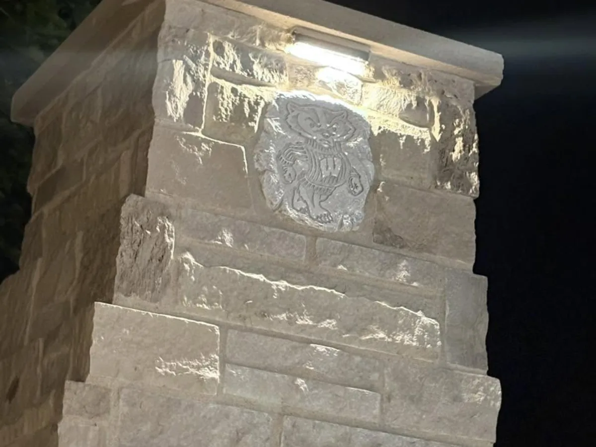 Close up of a cut stone fireplace surround with a carved medallion detail
