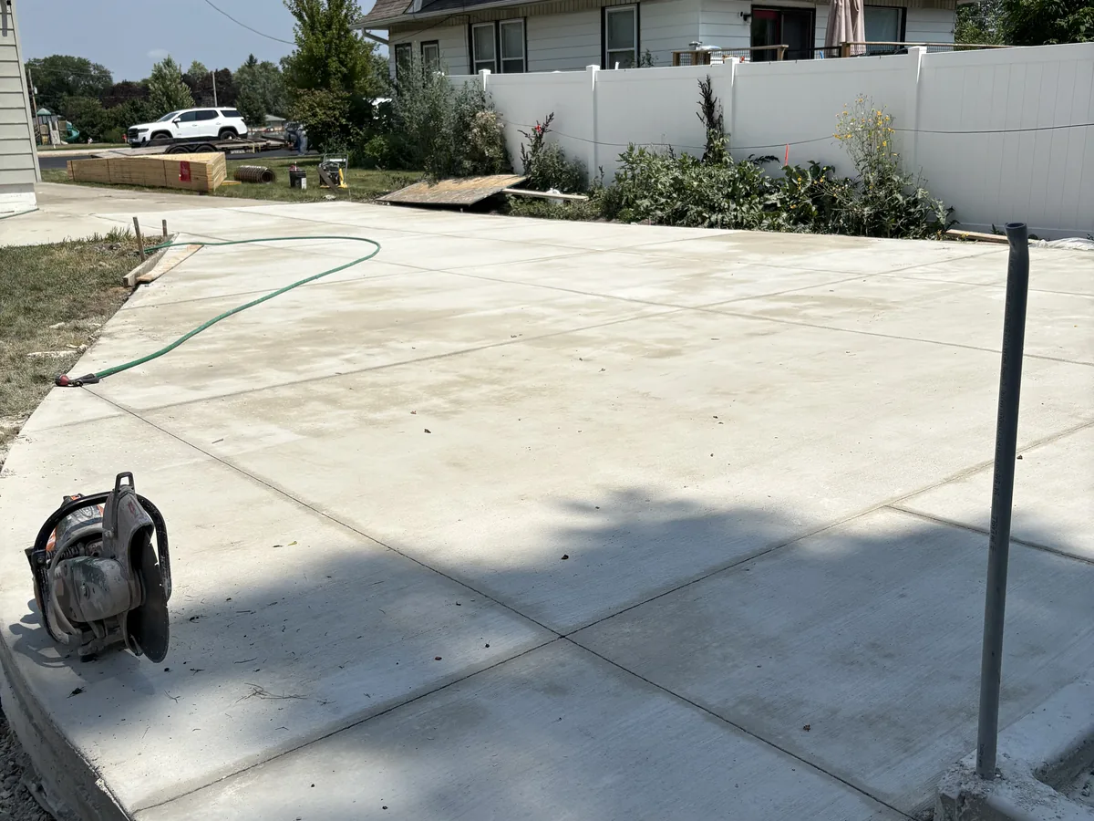 Large poured concrete patio slab in a fenced backyard