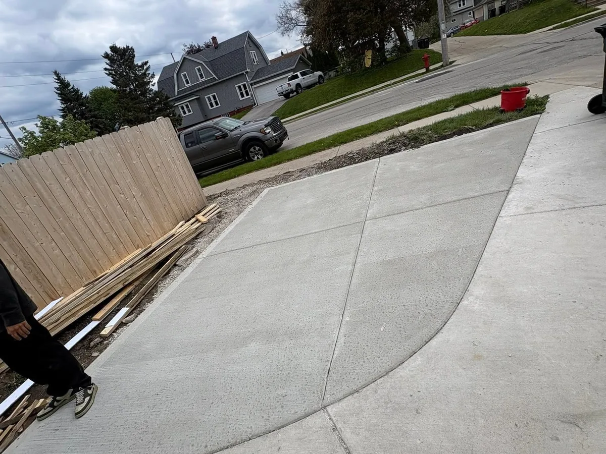 Finished concrete driveway running from the street up to a residential garage