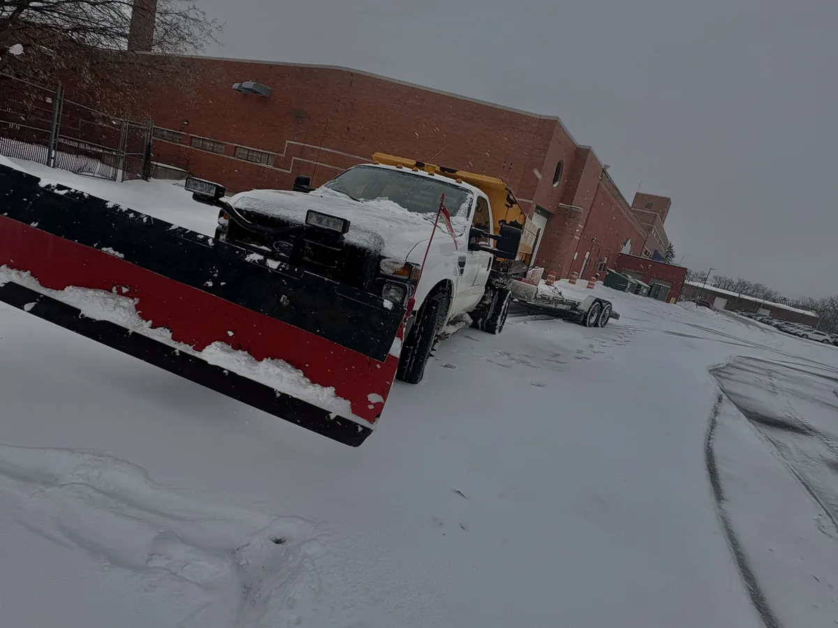 Plow truck clearing snow from a commercial parking lot